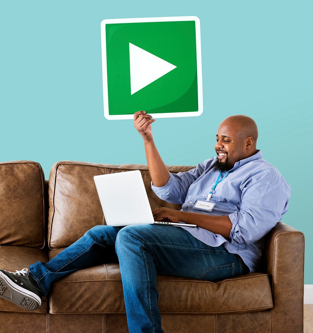 Man using a laptop and holding a play button