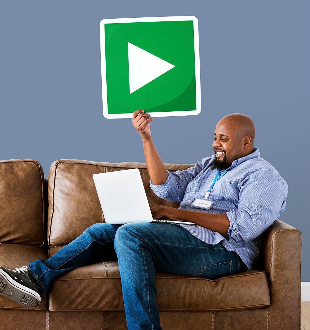 Man using a laptop and holding a play button