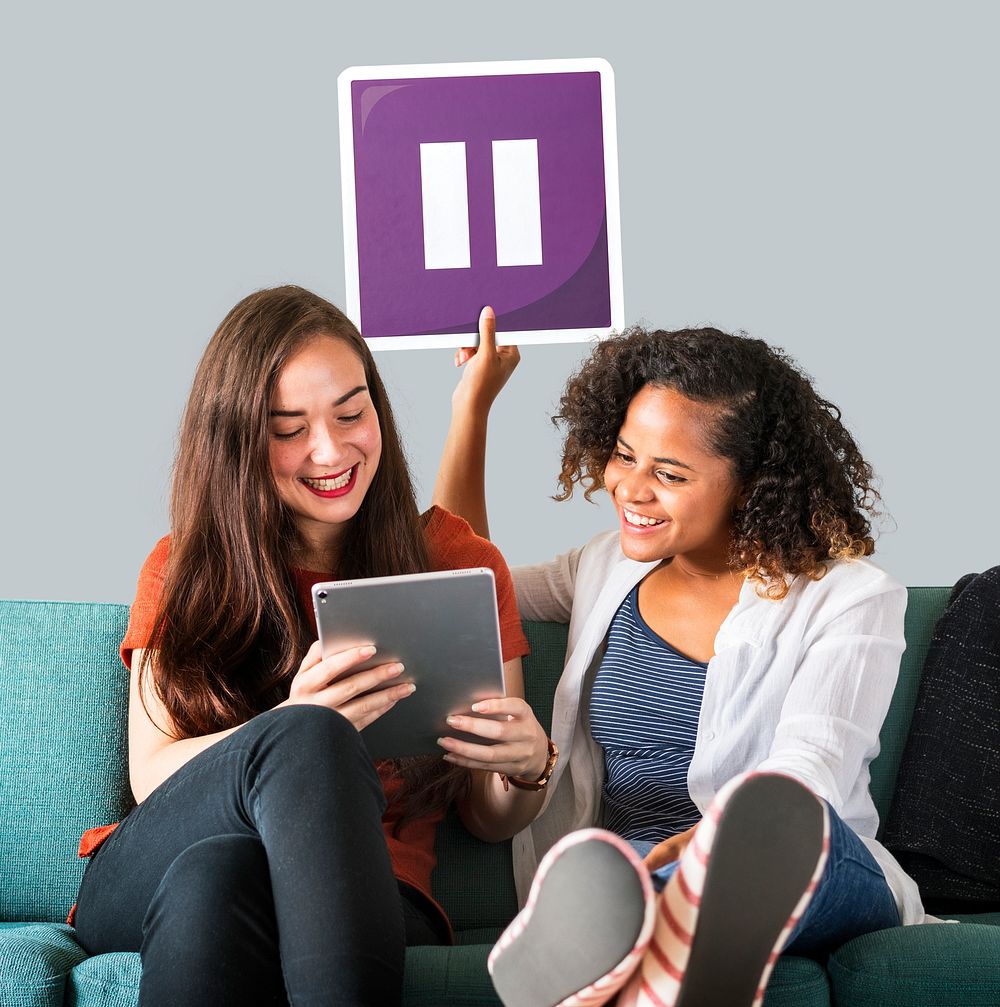 Young female friends holding a pause icon