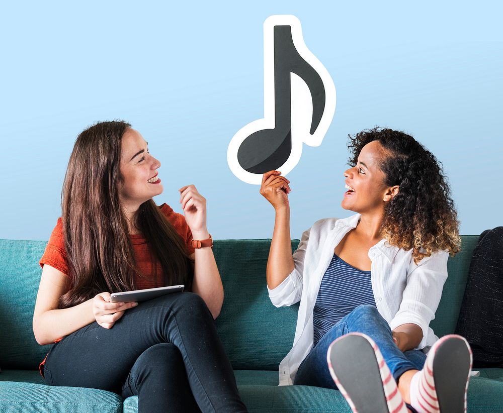 Young female friends holding a musical note icon