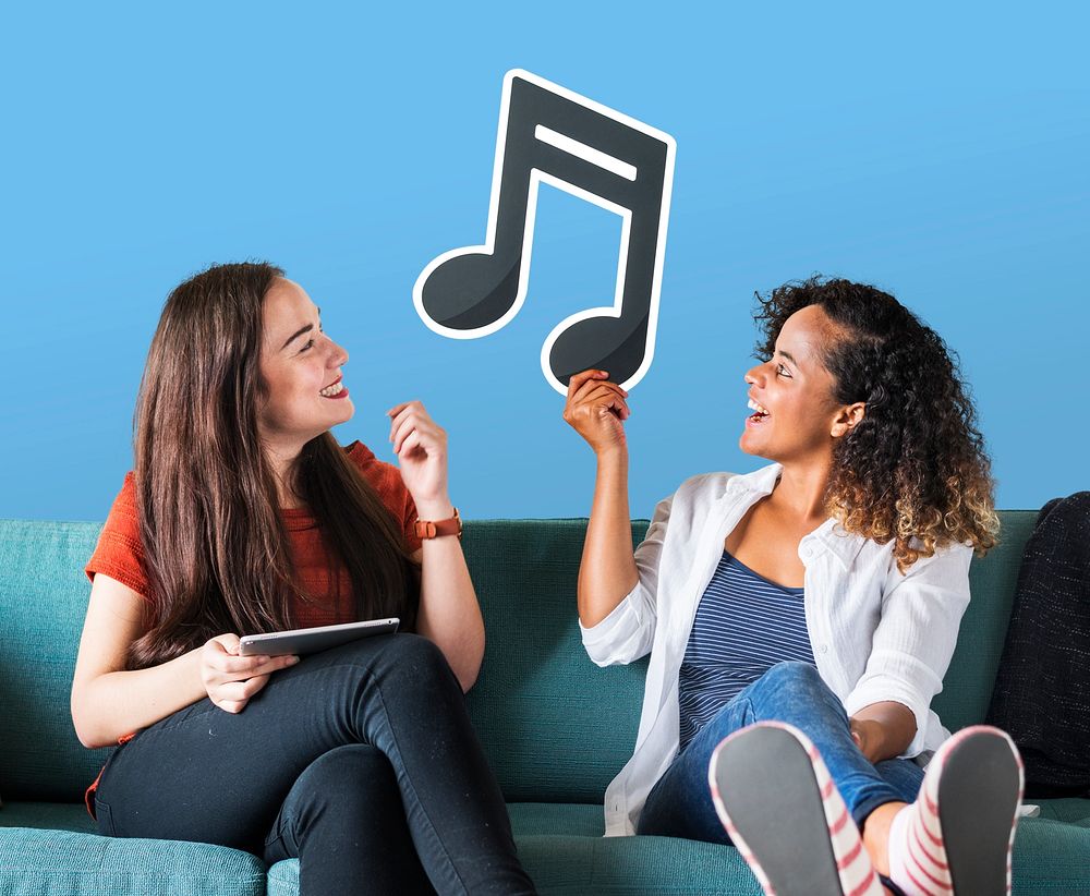 Young female friends holding a musical note icon