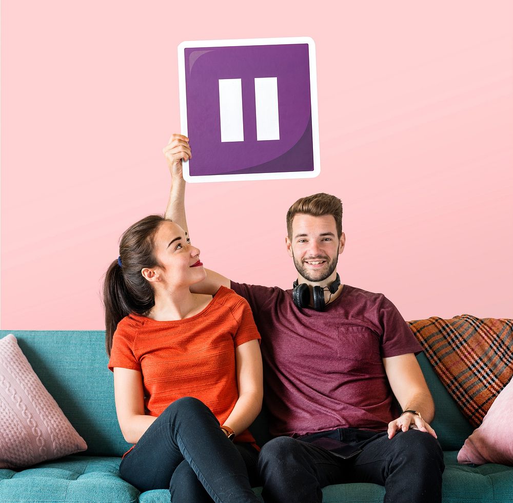 Young couple holding a pause button icon
