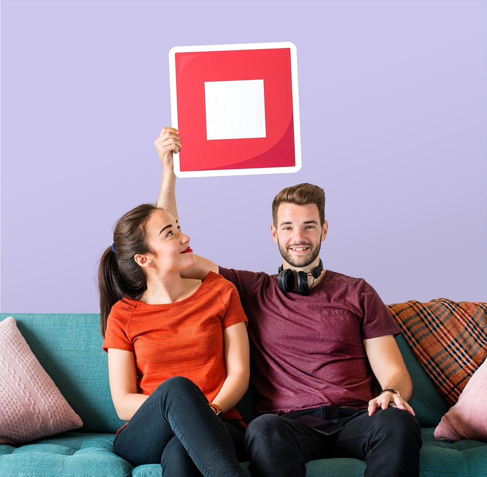 Young couple holding a stop button icon