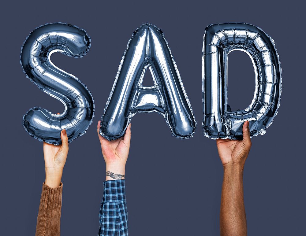 Hands showing sad balloons word