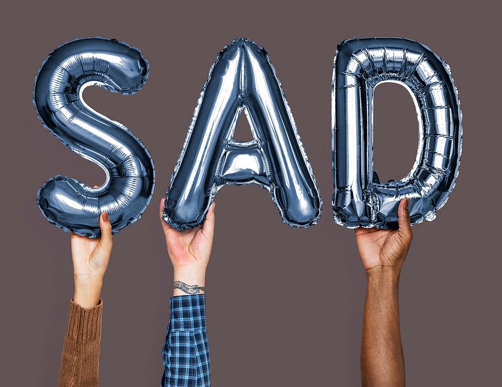 Hands showing sad balloons word