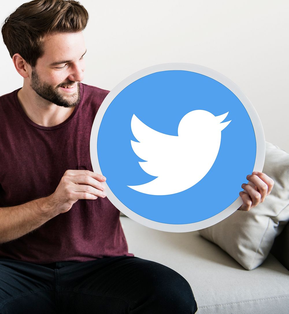 Cheerful man holding a Twitter icon