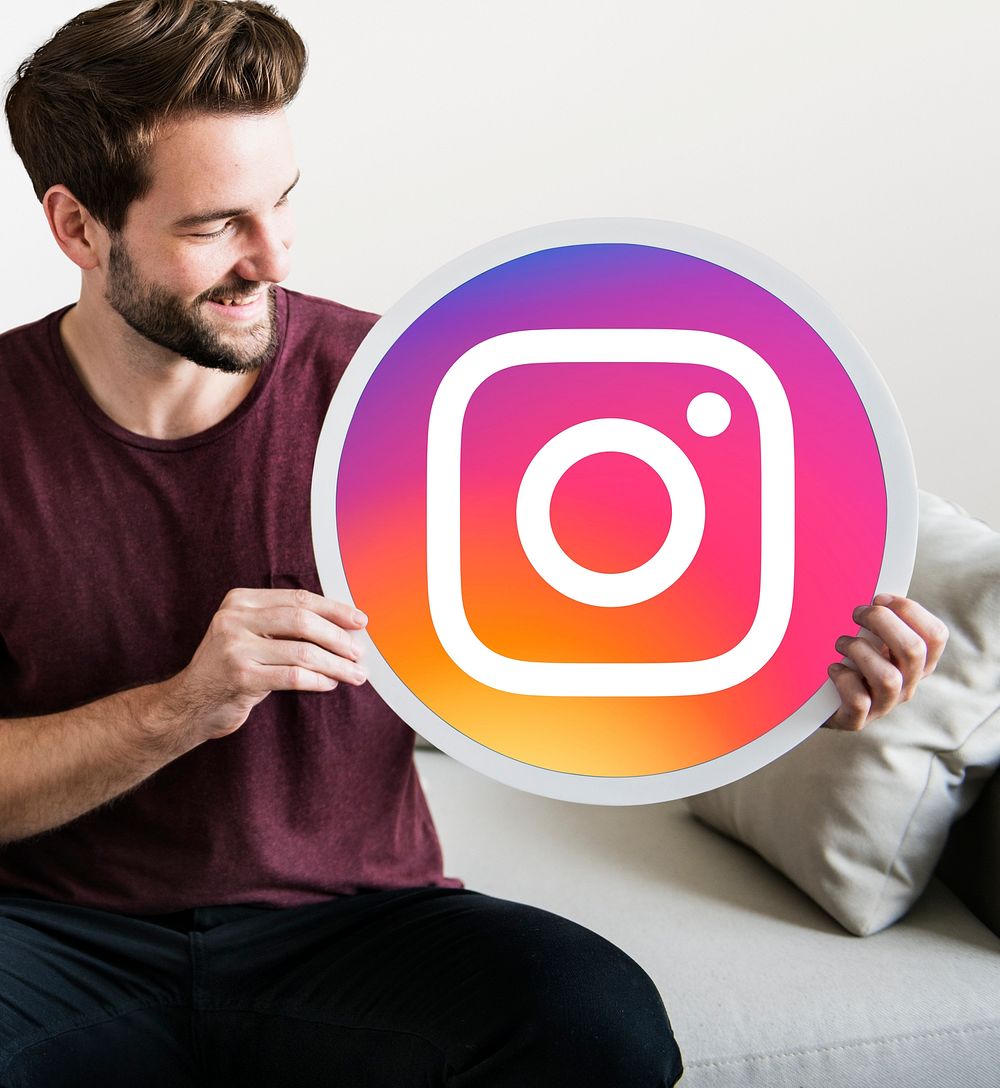 Cheerful man holding an Instagram icon