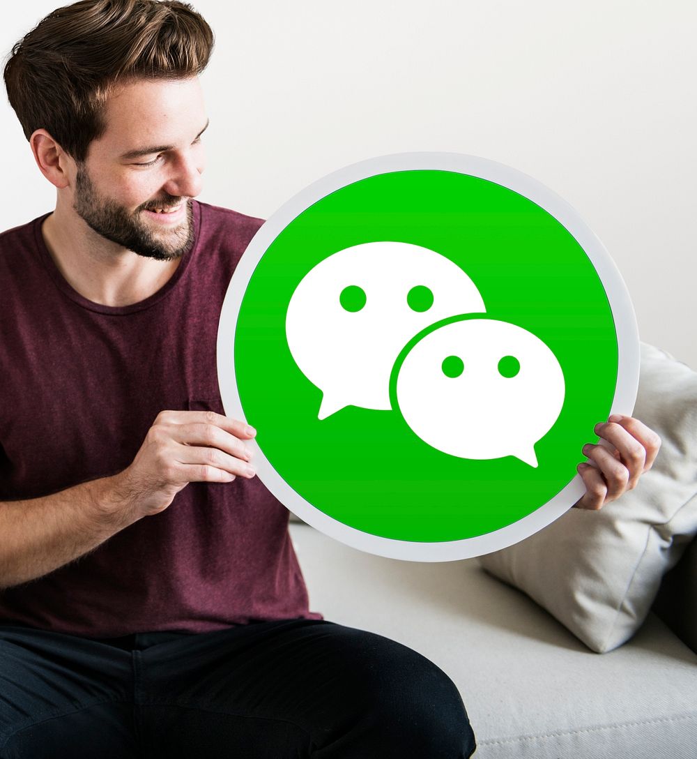 Cheerful man holding a WeChat icon