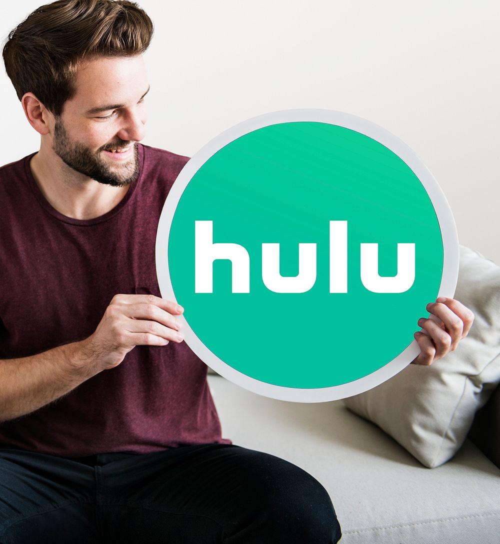 Cheerful man holding a Hulu icon