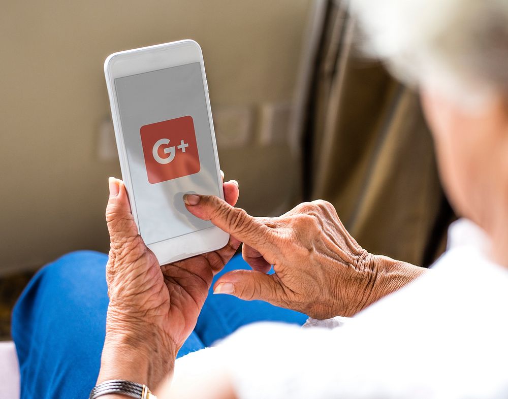 Elderly woman using Google Plus application on a phone. BANGKOK, THAILAND, 1 NOV 2018.