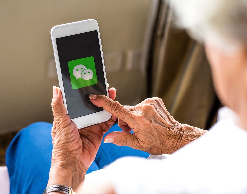 Elderly woman using WeChat application on a phone. BANGKOK, THAILAND, 1 NOV 2018.