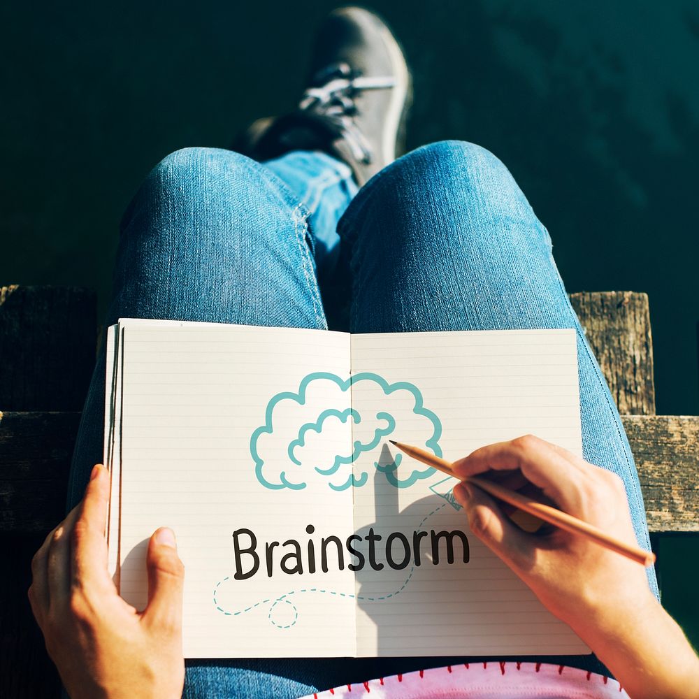 Woman writing Brainstorm on a notebook
