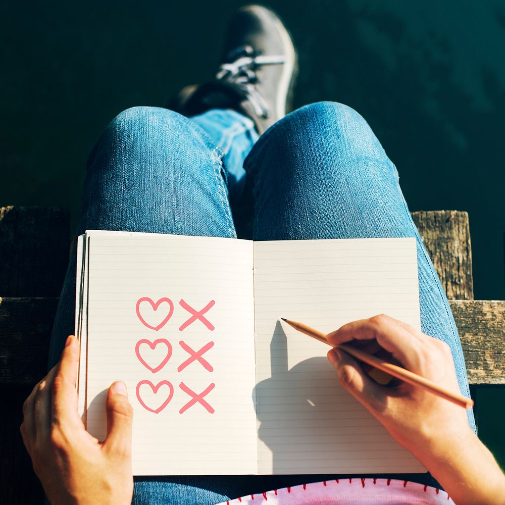 Woman drawing hearts and kisses on a notebook