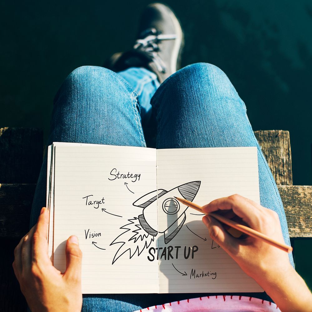 Woman drawing startup ideas in a notebook