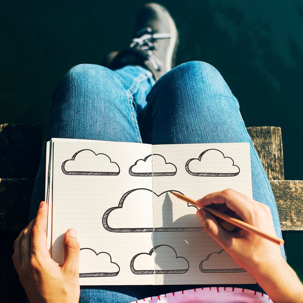 Woman drawing empty clouds in a notebook