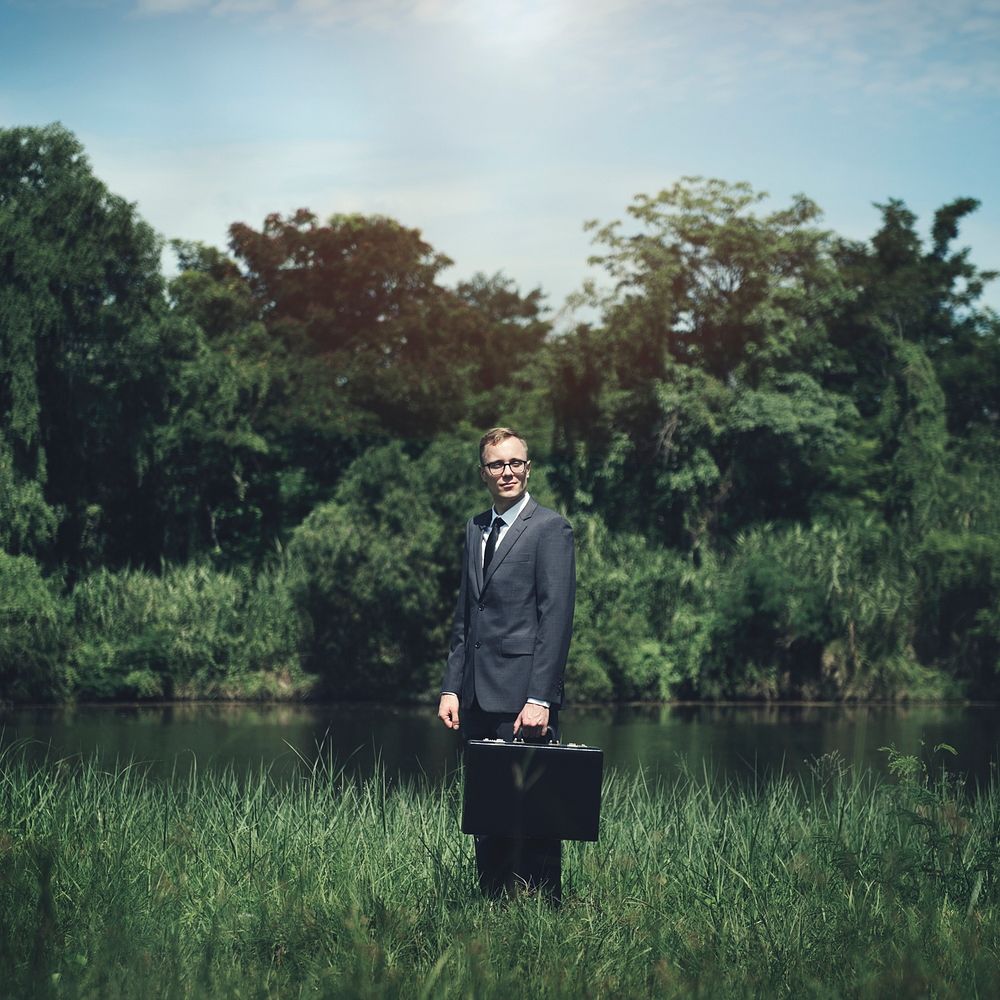 Businessman standing on a grassland