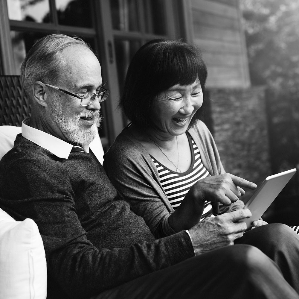 Senior couple sitting using tablet together