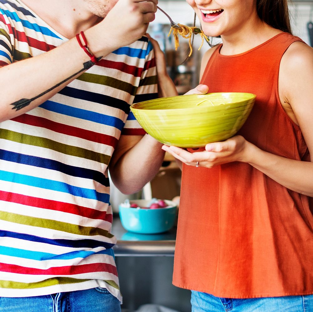Couple sharing eating a bowl of spaghetti