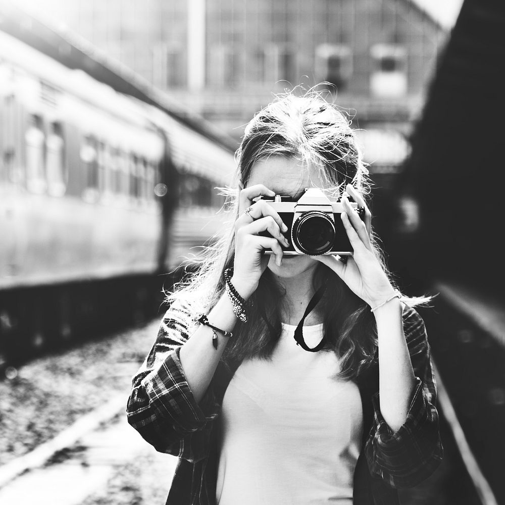 Young woman is taking photo with film camera