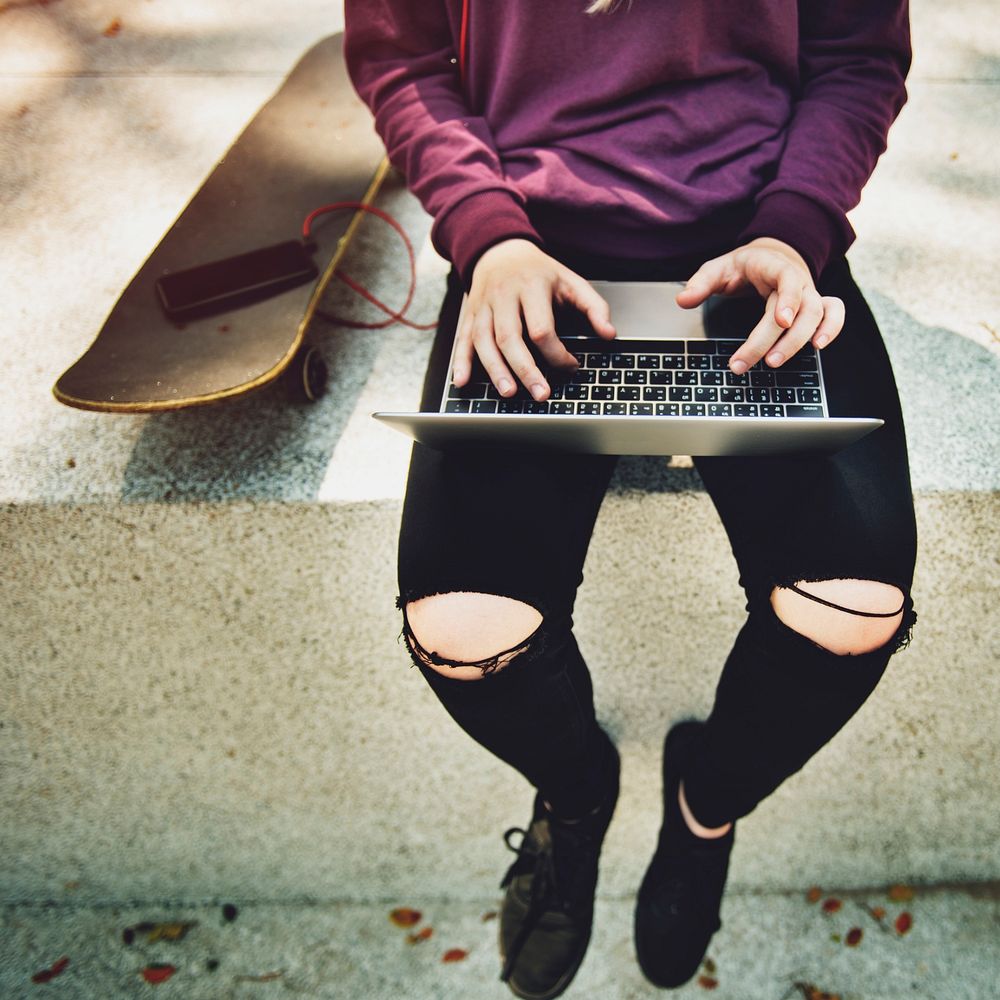 Young skater girl using a laptop