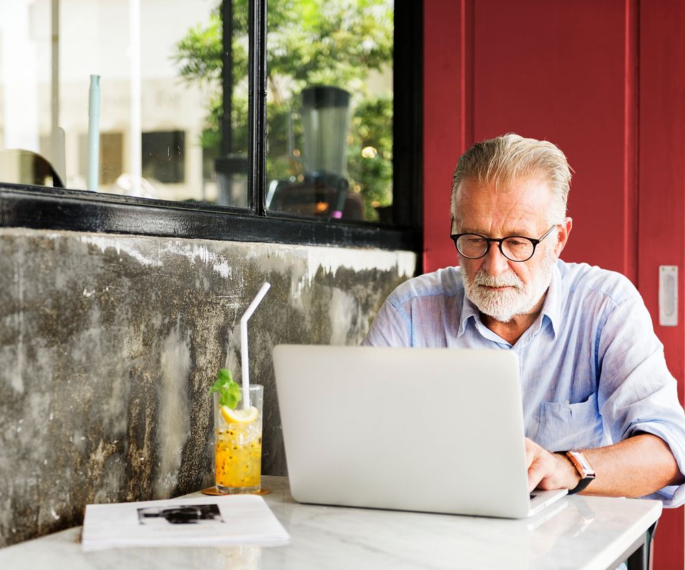 Elderly man is using computer laptop