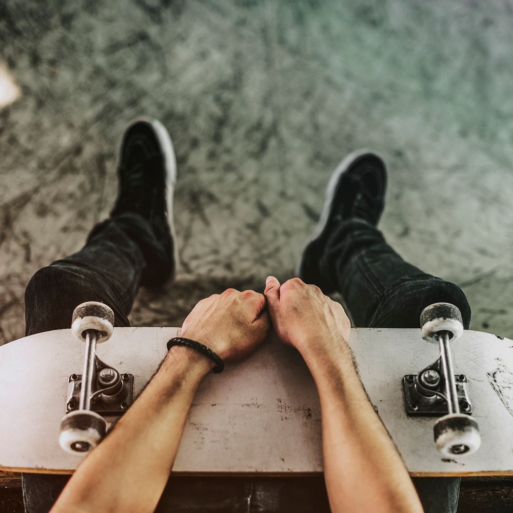 Man holding his white skateboard