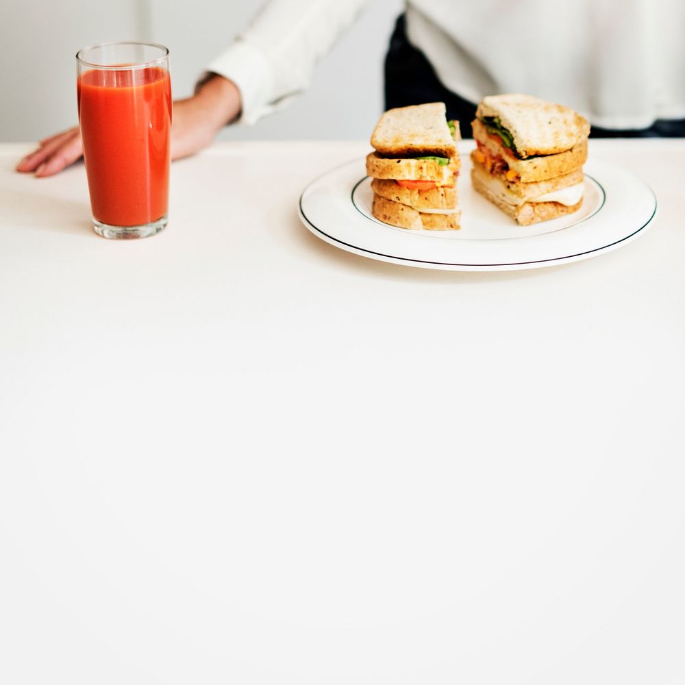 Closeup of sandwich and juice on white table