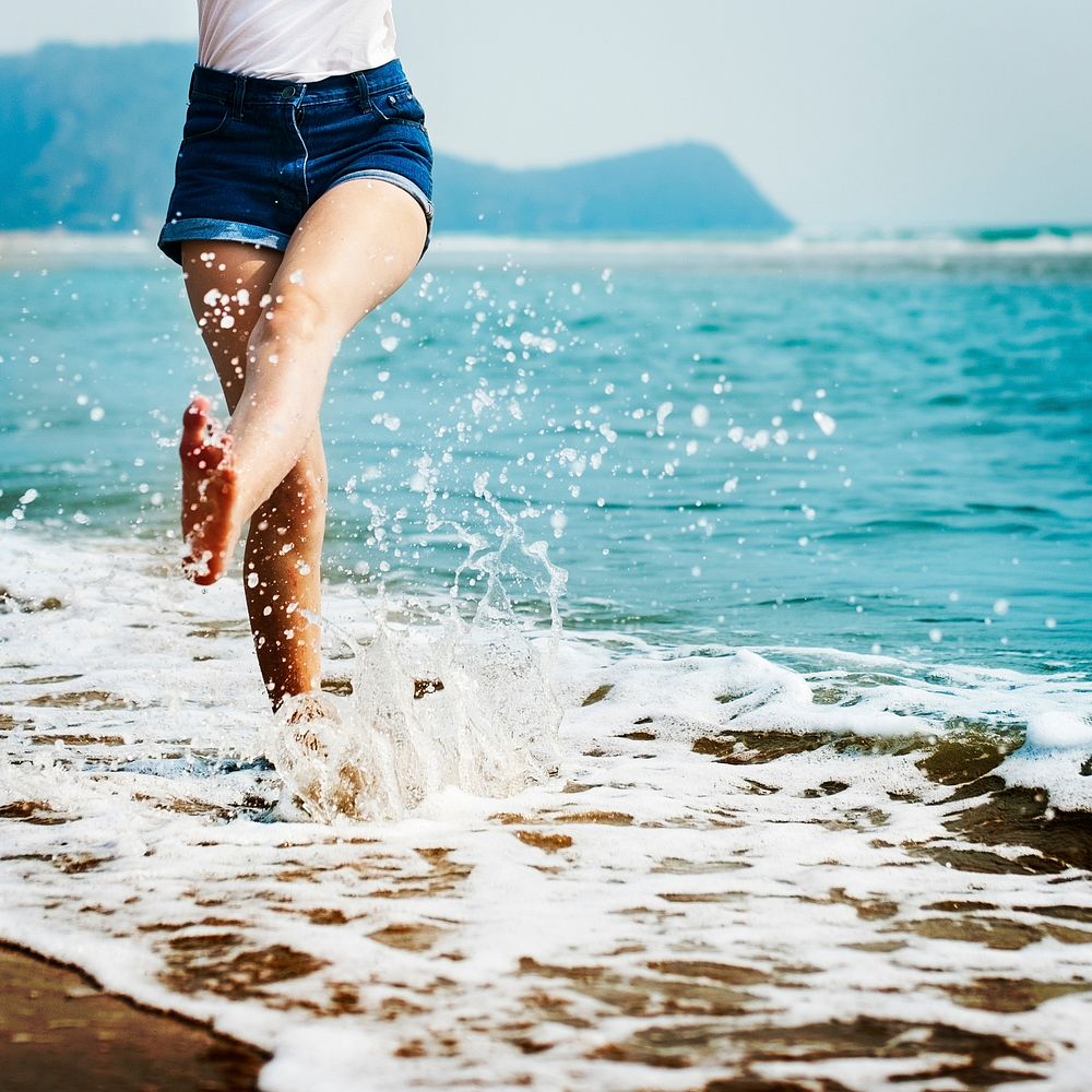 Woman feet splashing sea water
