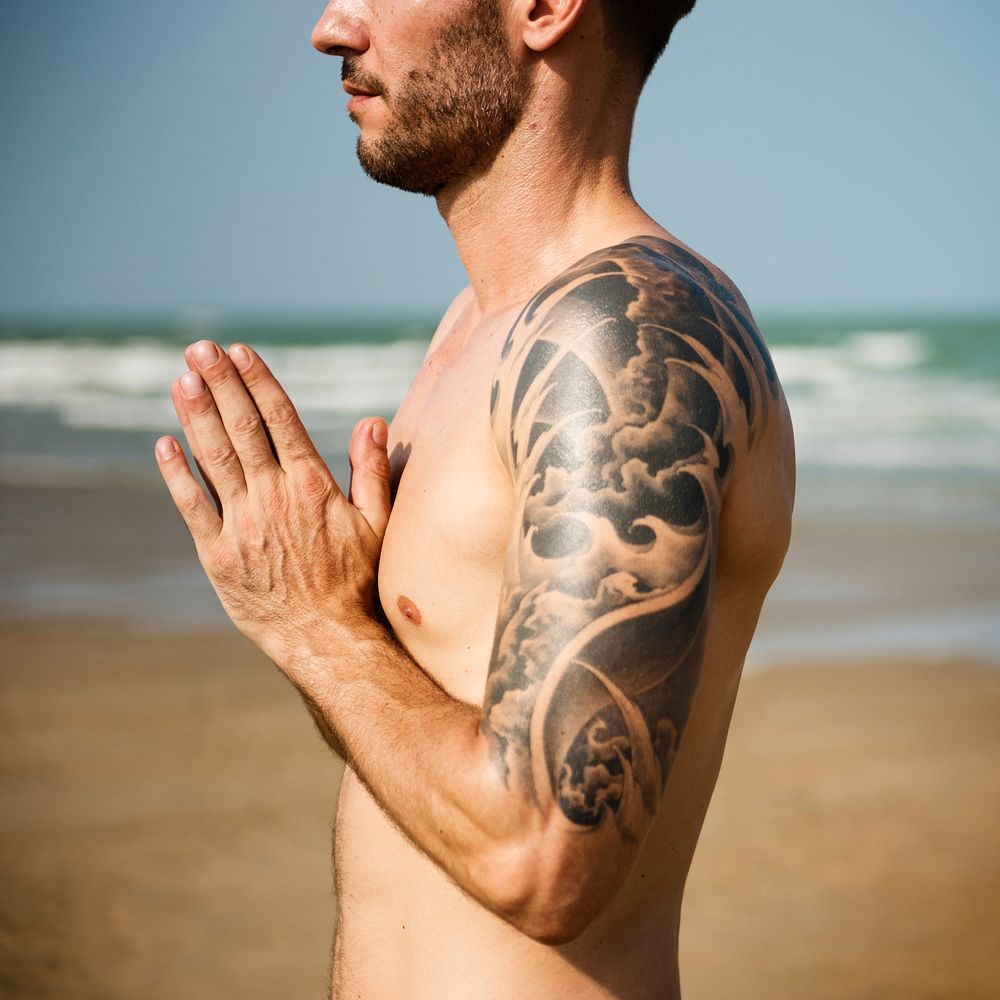 A man is doing a yoga at the beach