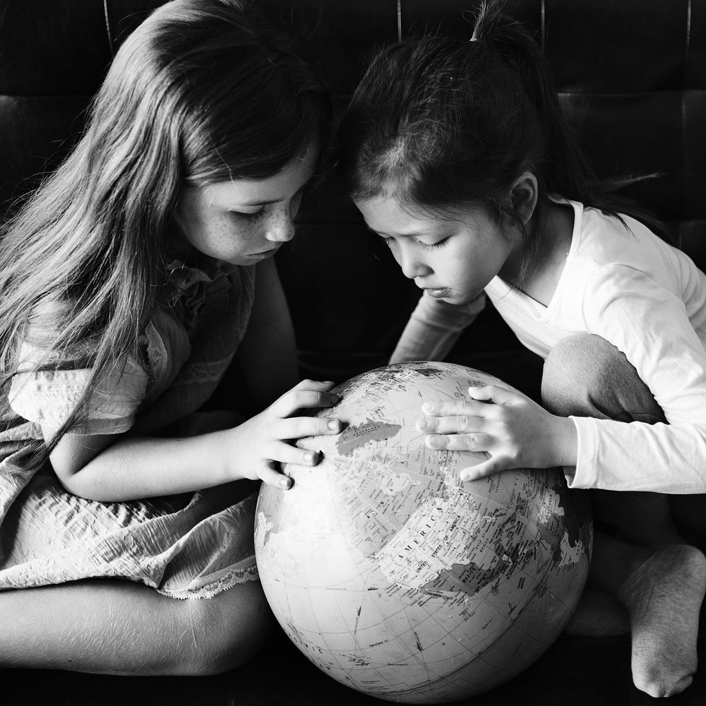 Little girls playing with a globe
