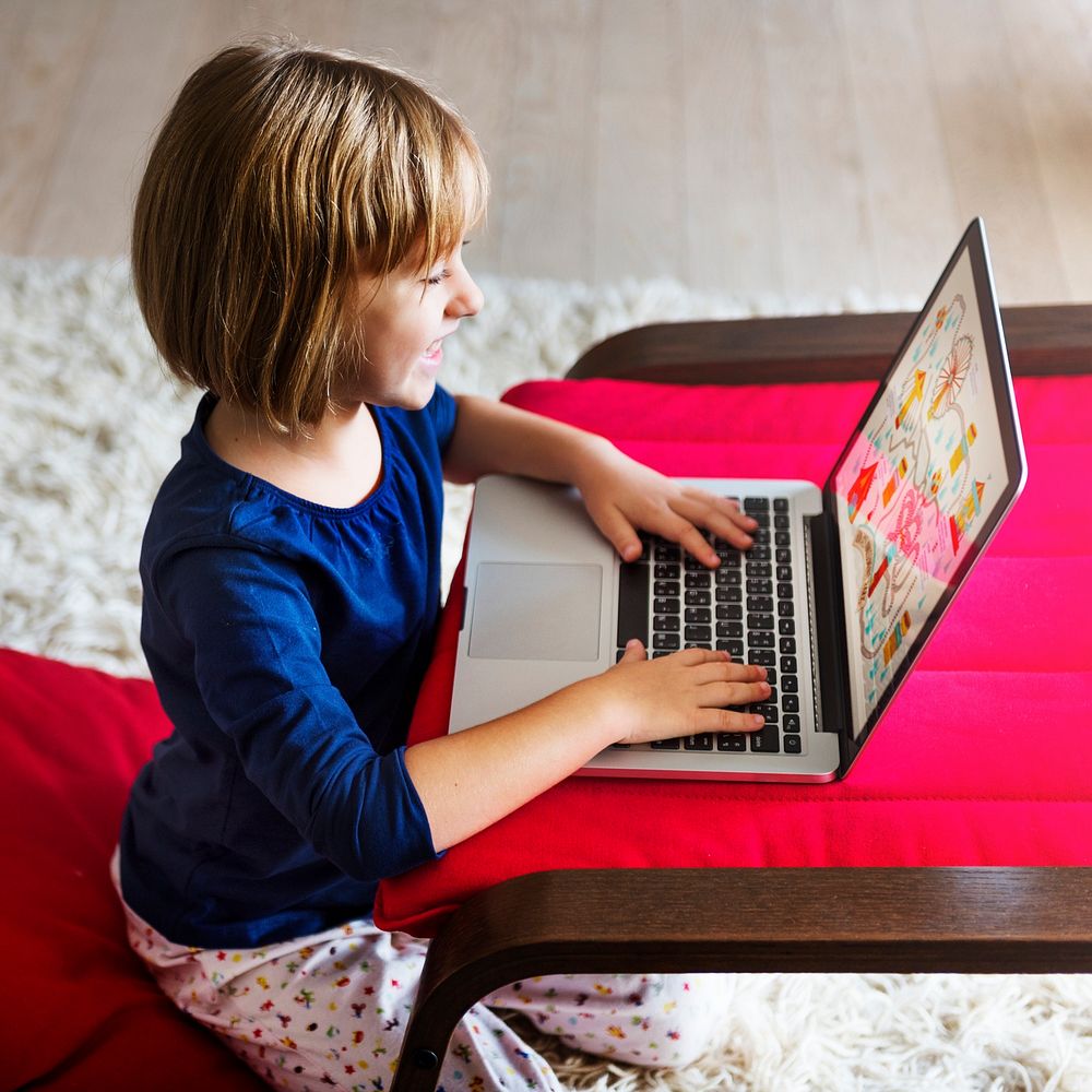 Little girl playing on a laptop