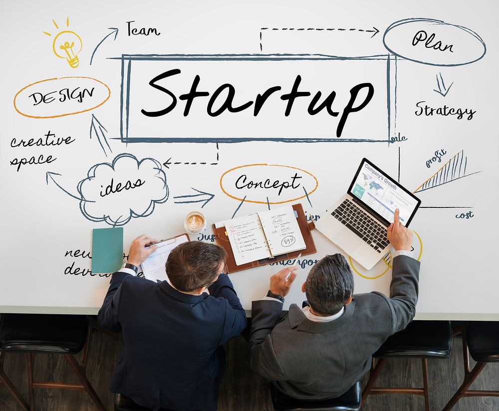 Start up diagram on a table with two businessmen