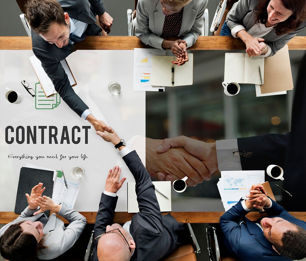 Contract word on business handshake background