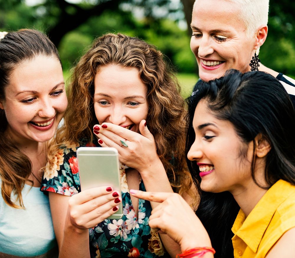 Women laughing at something on a phone