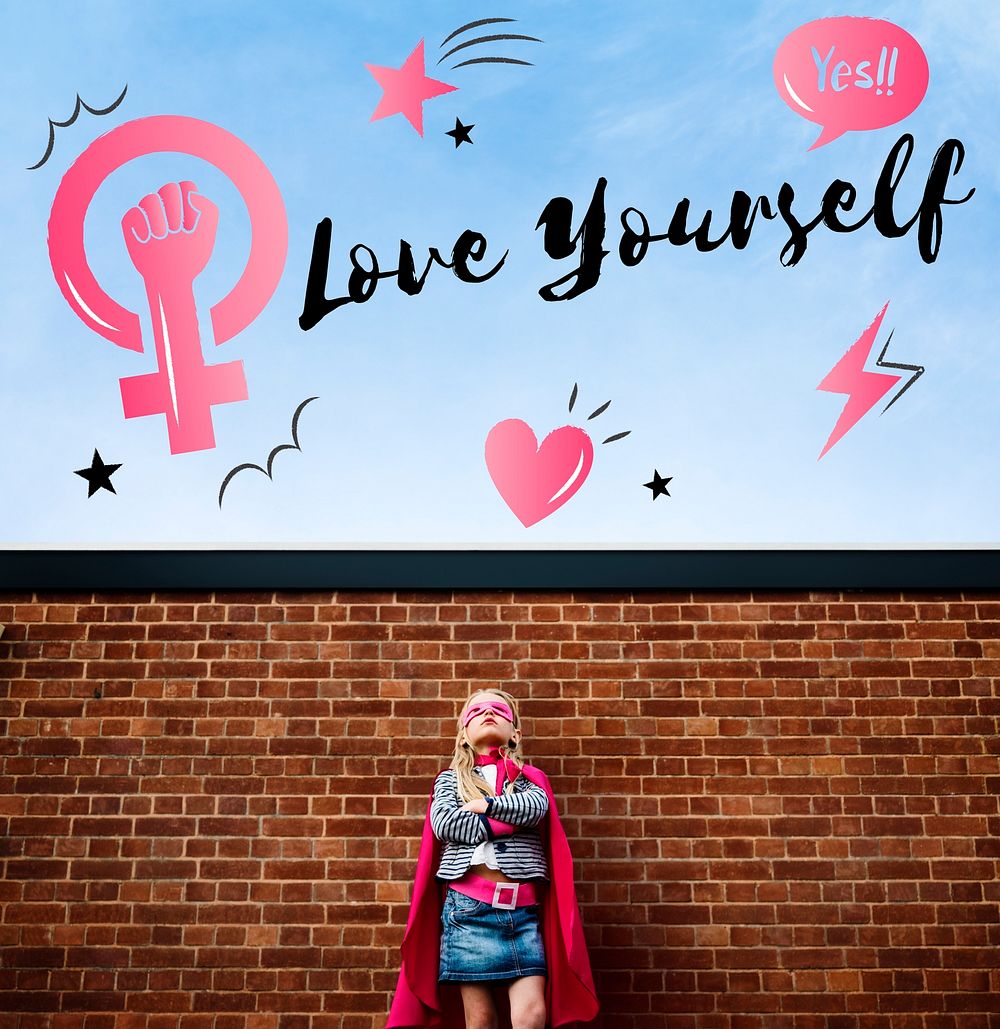 Superhero girl looking up at Love Yourself text in the sky