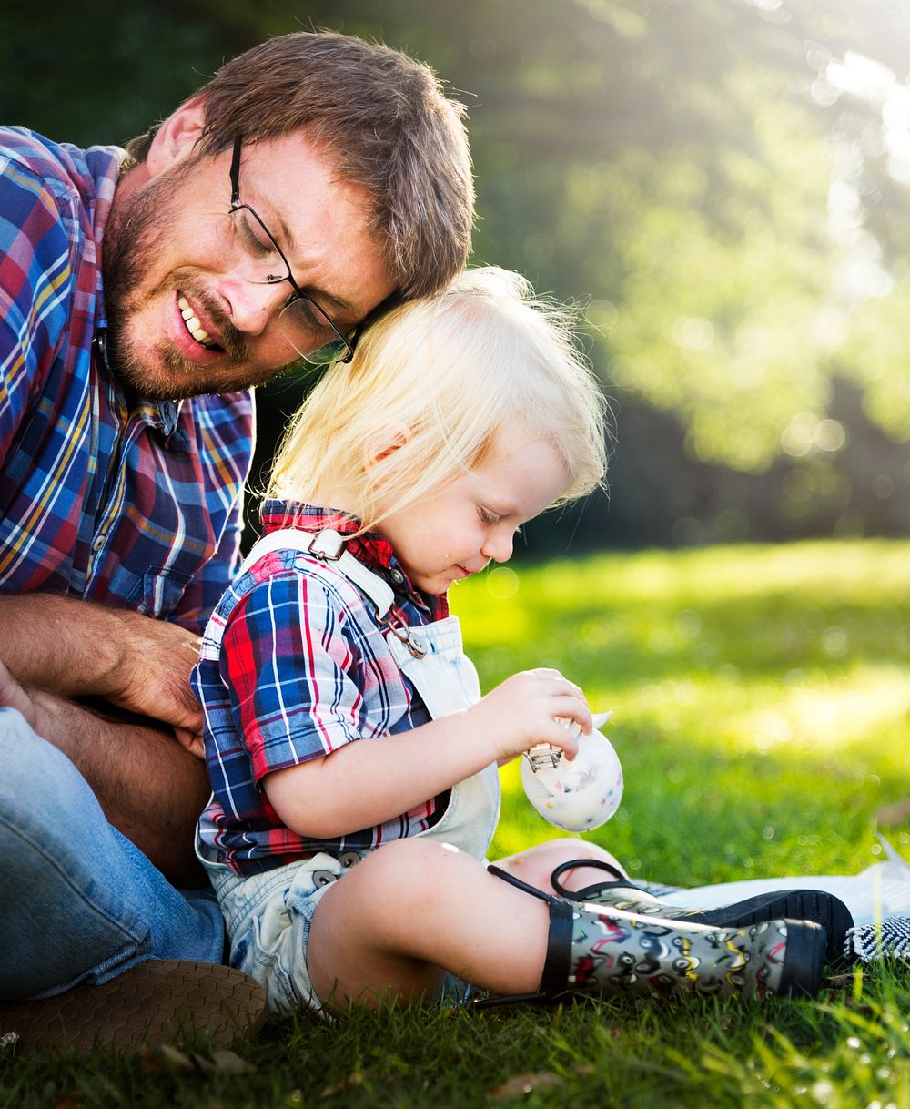 Happy father and son sitting in a park