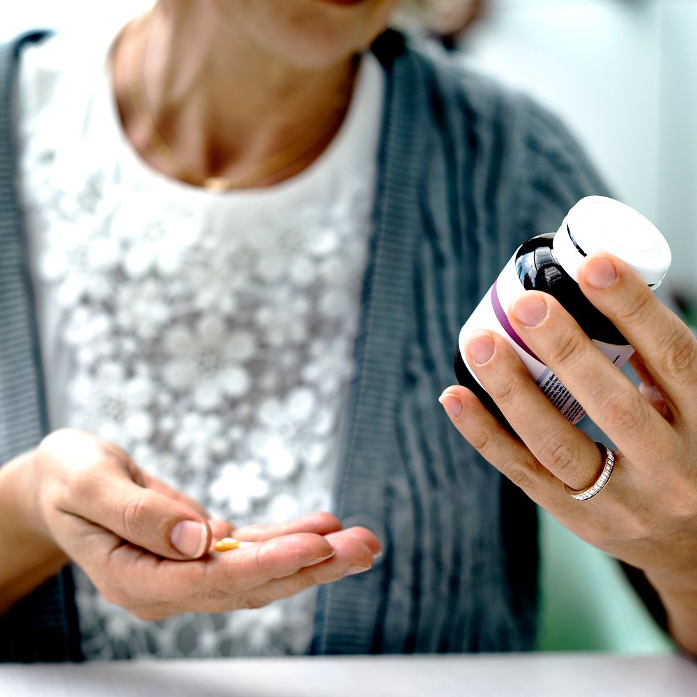Elderly woman taking pills