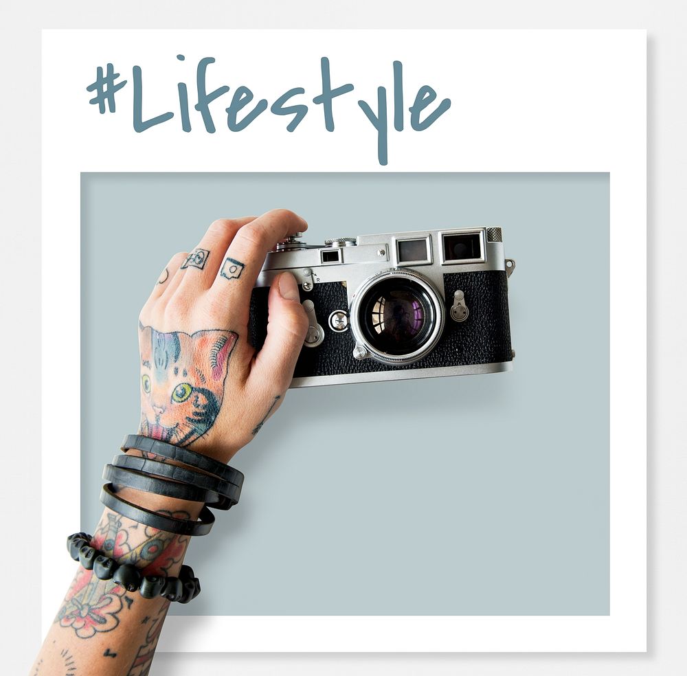 Tattooed hand holding an analog film camera