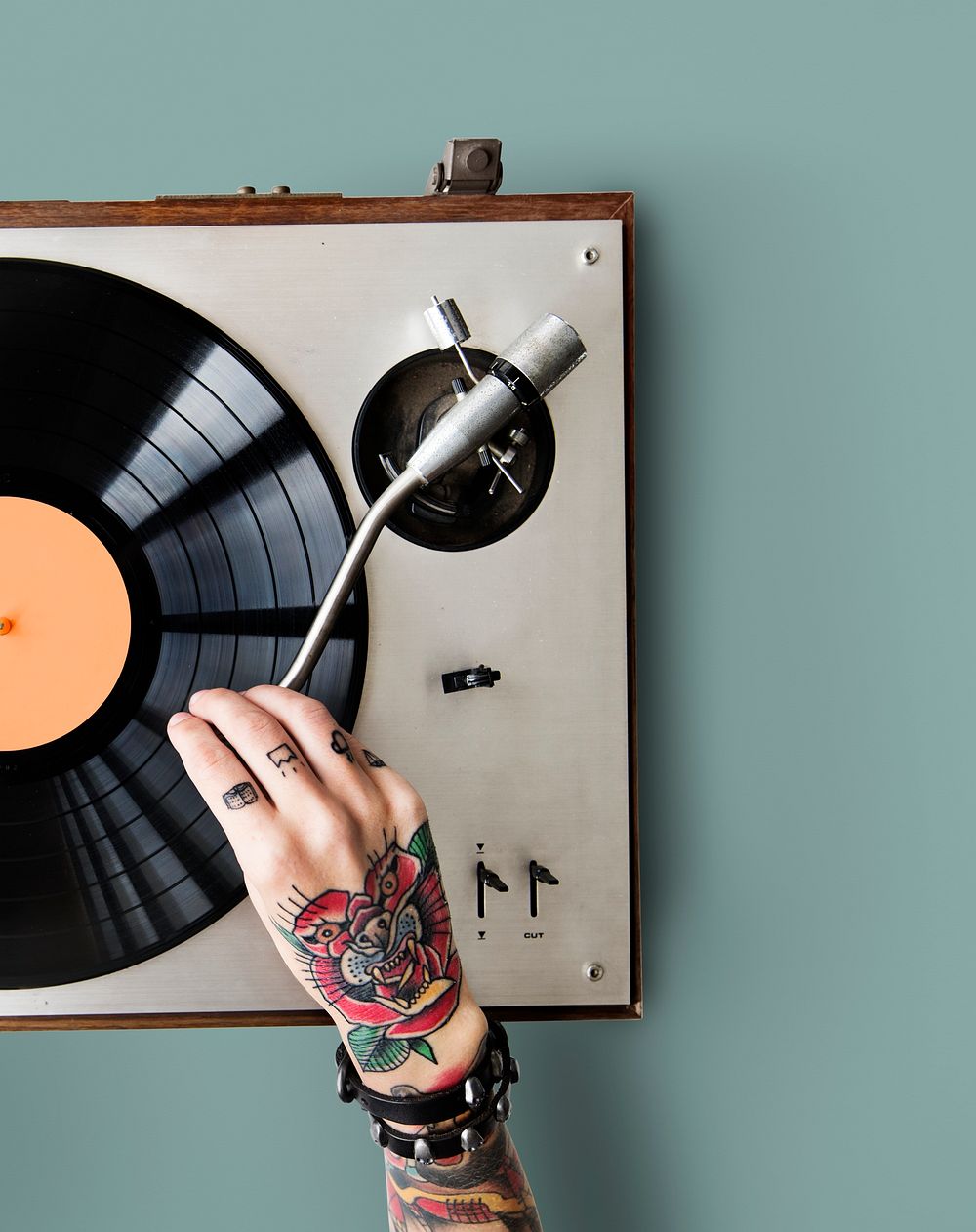 Tattooed woman playing a vinyl record