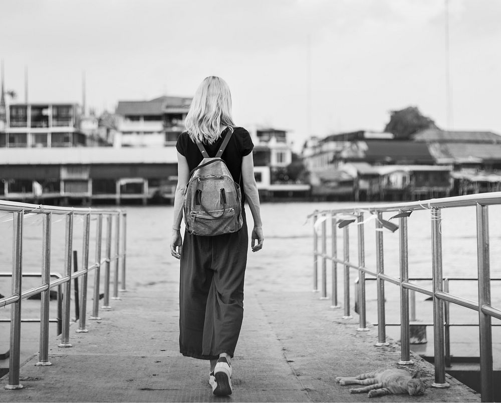 Rear view of traveler walking on a dock