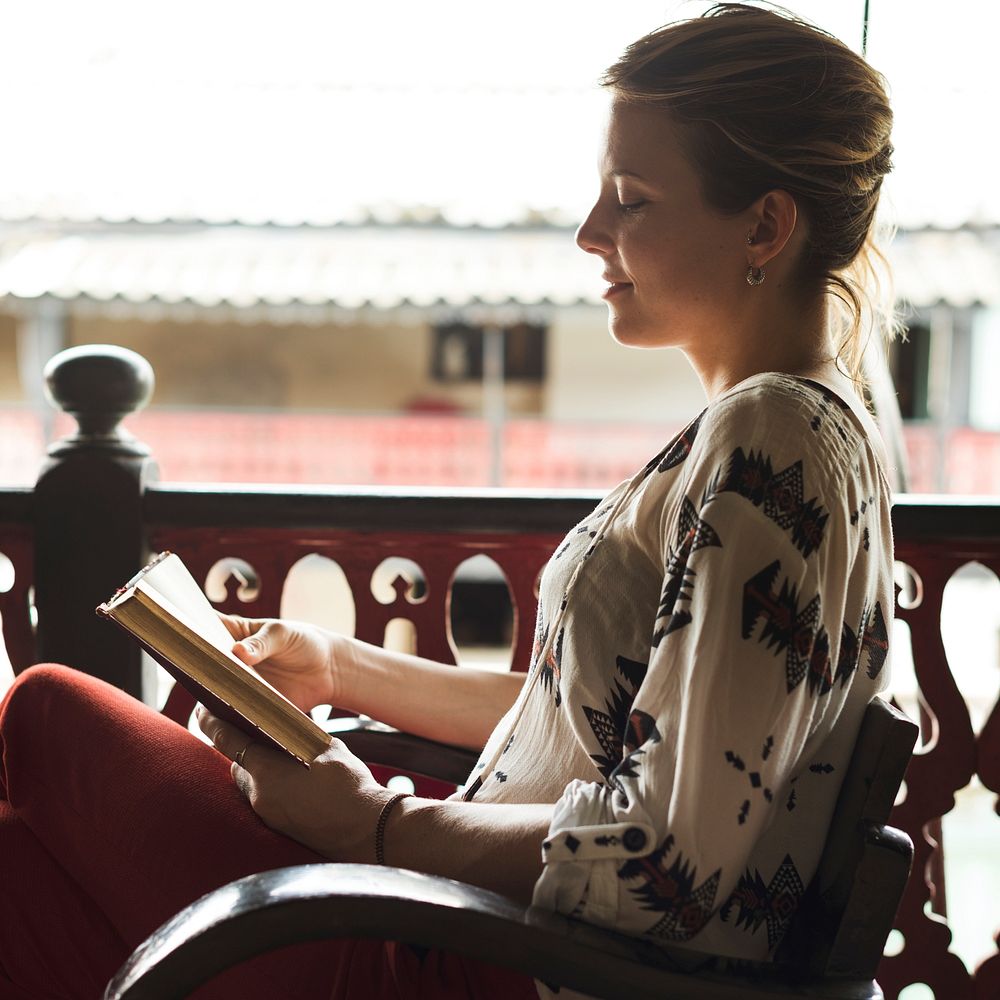 Caucasian woman reading the book at the balcony