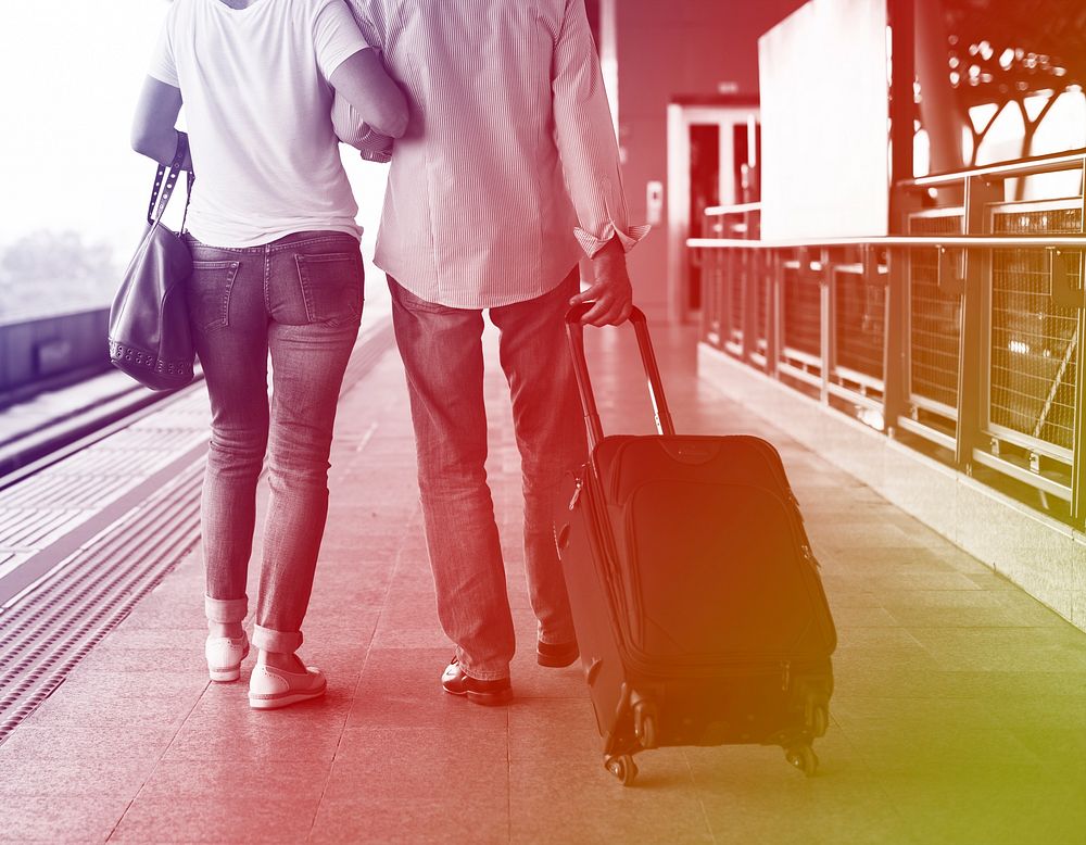 Senior adult couple with traveling luggage at train station