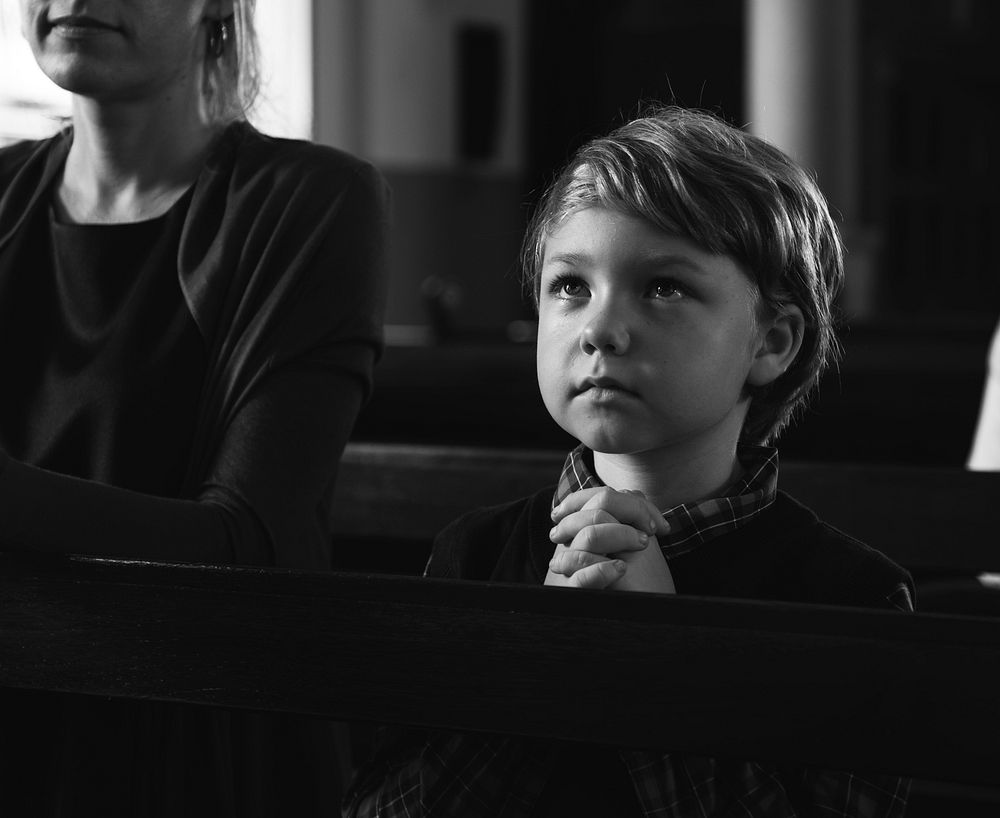 Little boy praying inside a church