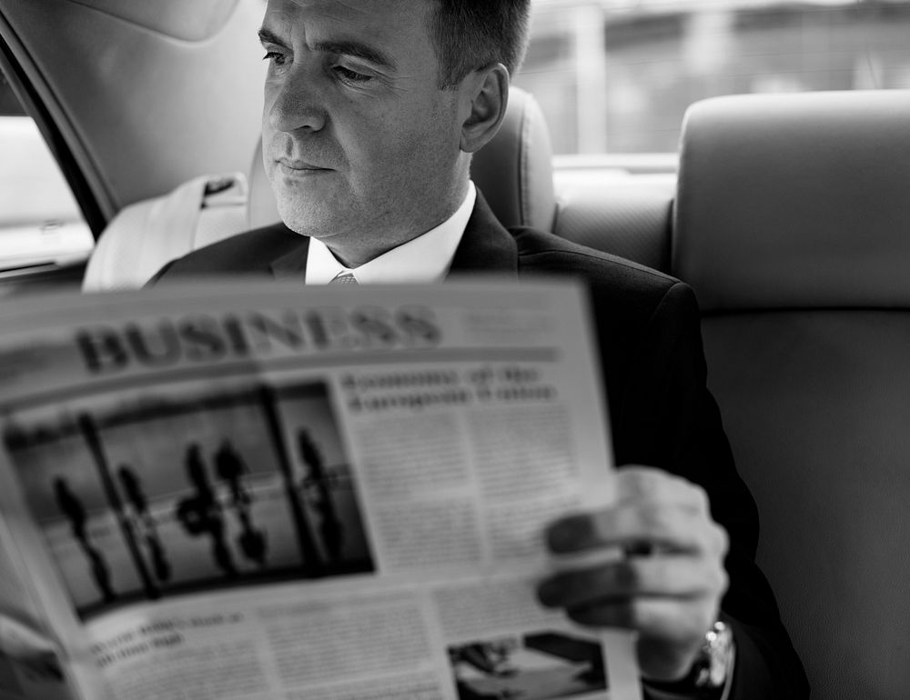 Businessman reading a newspaper in a car