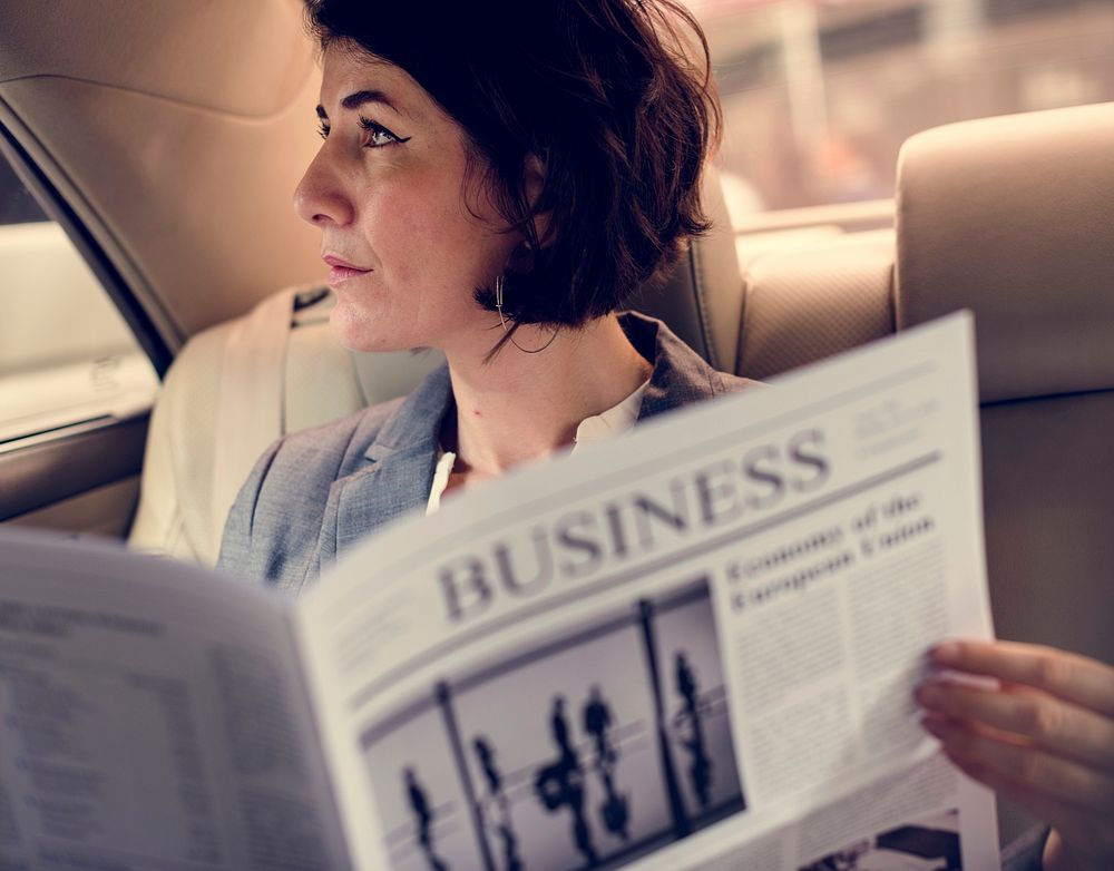 Businesswoman Reading Newspaper Car Inside