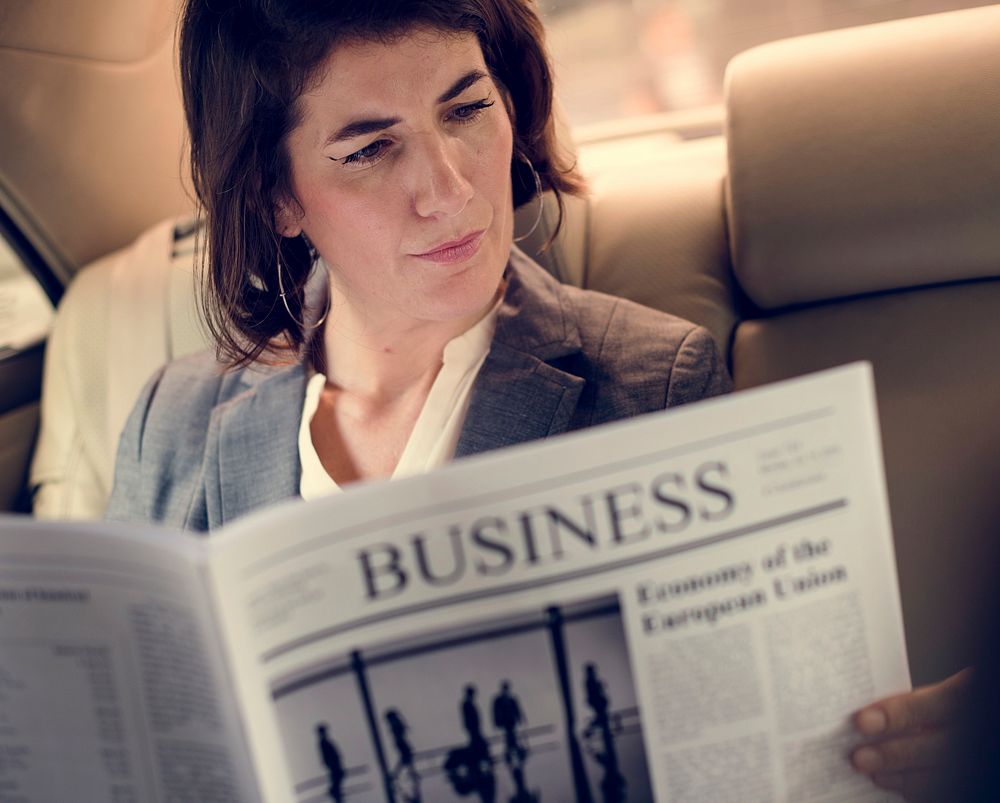 Businesswoman Reading Newspaper Car Inside