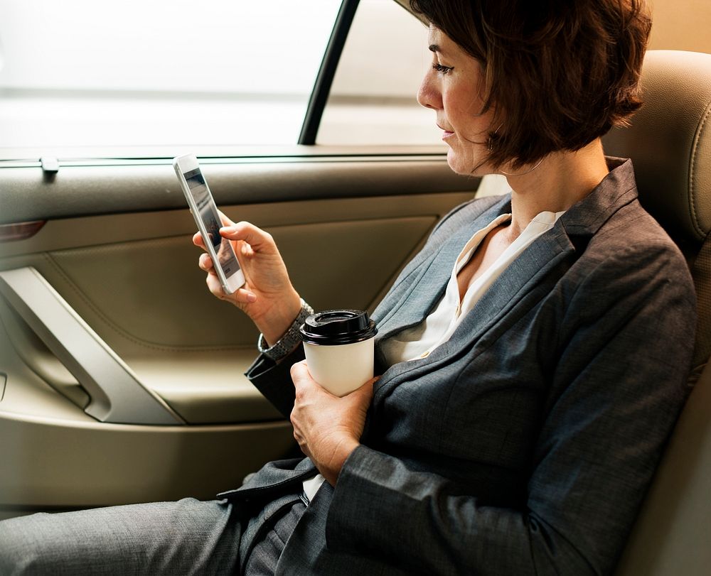 Businesswoman Using Smart Phone Car Inside