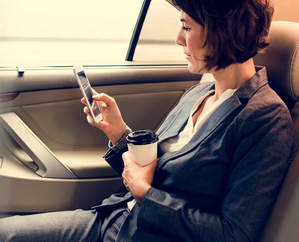 Businesswoman Using Smart Phone Car Inside