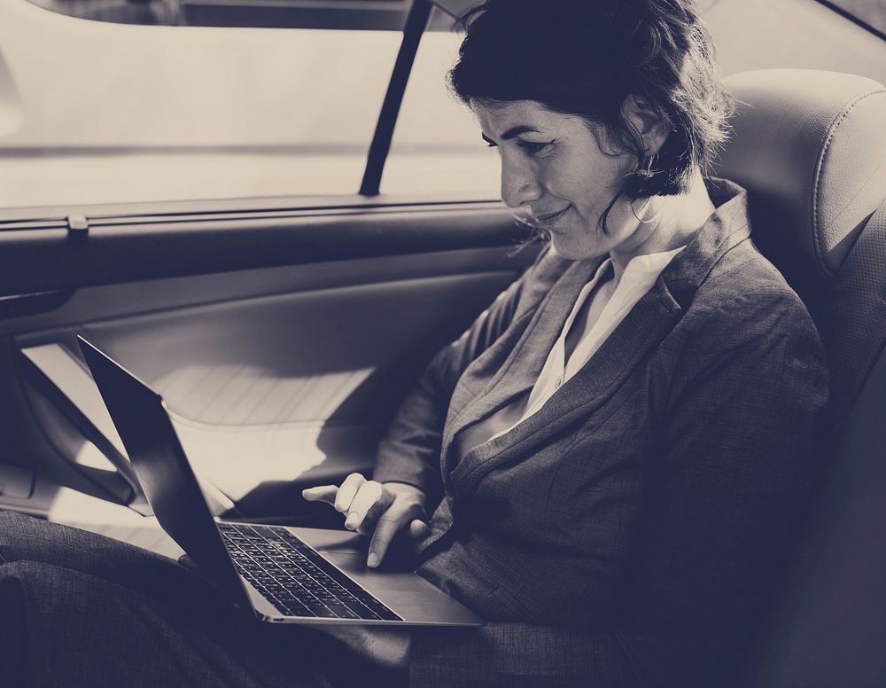 Businesswoman Working Using Laptop Car Inside