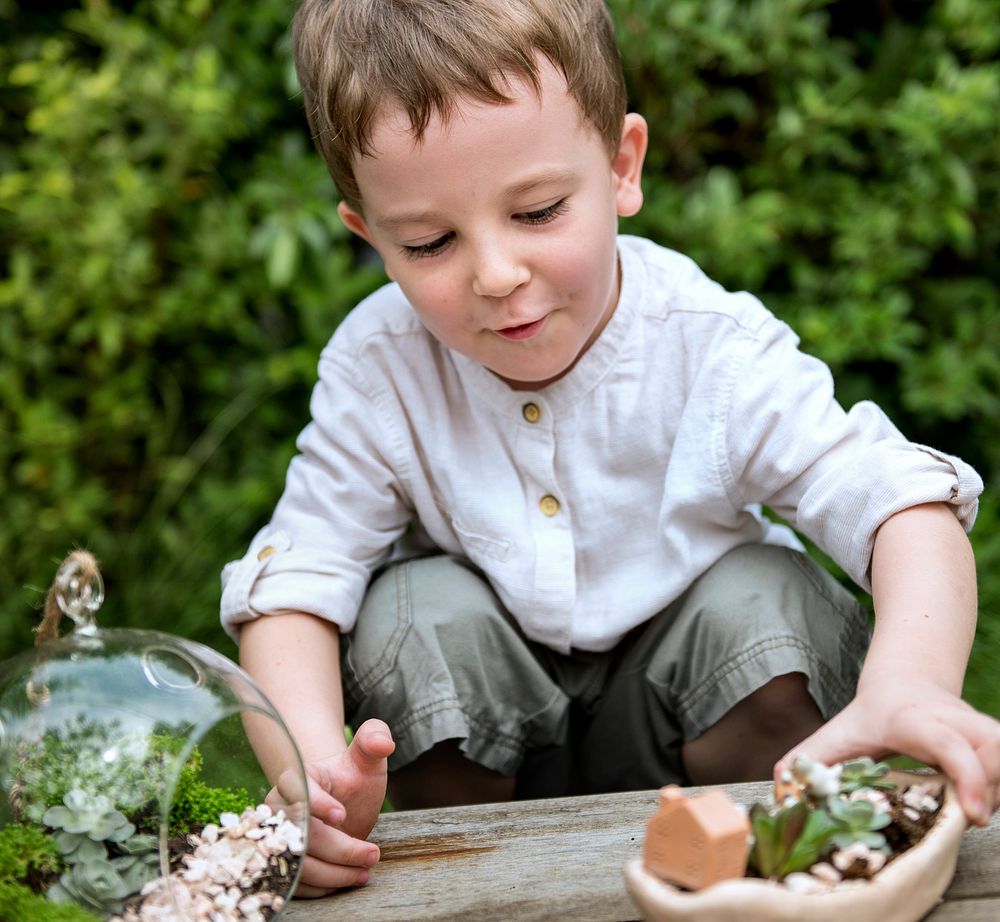 Little young boy playing with plants